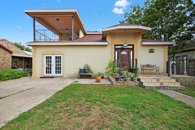 1321 Lindberg St, Odessa, TX 79763 - rear view of property with french doors, a balcony, a lawn, stucco siding, and a patio