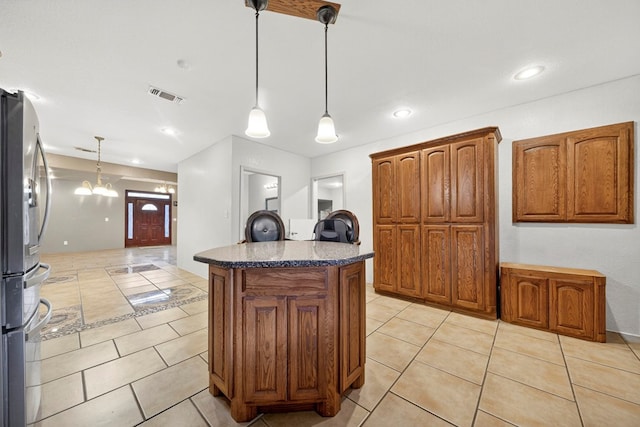 1321 Lindberg St, Odessa, TX 79763 - kitchen with freestanding refrigerator, a kitchen island, light tile patterned flooring, brown cabinetry, and recessed lighting