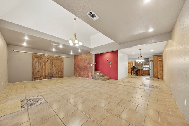 1321 Lindberg St, Odessa, TX 79763 - unfurnished living room featuring a chandelier, a barn door, recessed lighting, and light tile patterned flooring