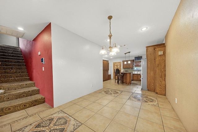 1321 Lindberg St, Odessa, TX 79763 - kitchen with freestanding refrigerator, light tile patterned flooring, brown cabinetry, a center island, and recessed lighting