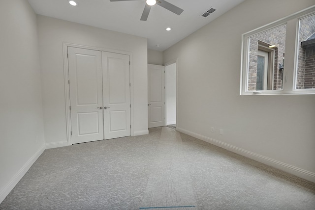 unfurnished bedroom featuring visible vents, carpet, baseboards, and a closet