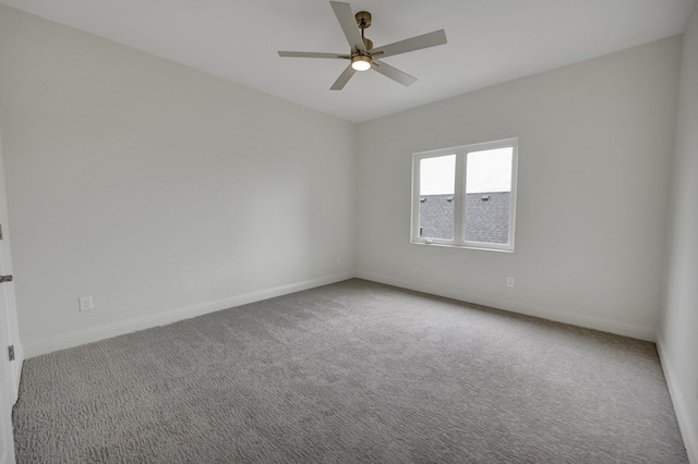 carpeted spare room featuring baseboards and ceiling fan
