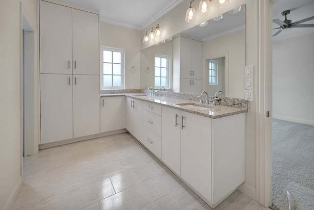 bathroom with crown molding, double vanity, ceiling fan, and a sink