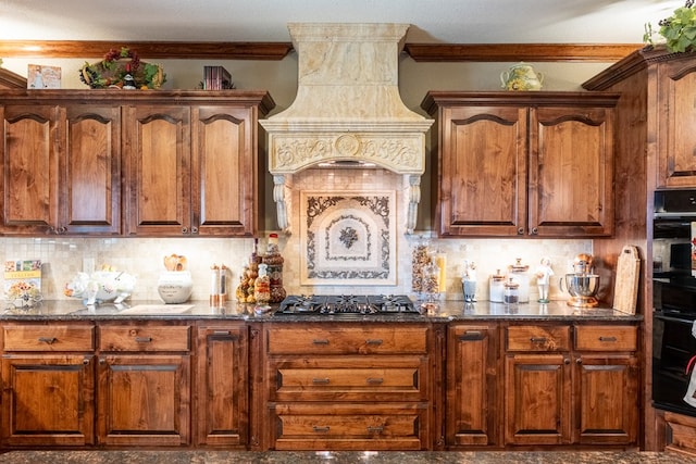 651 Fm 1757, Seminole, TX 79360 - kitchen with stainless steel gas cooktop, premium range hood, ornamental molding, decorative backsplash, and dark stone countertops