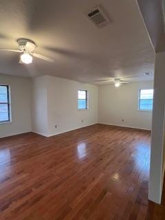 unfurnished room with a wealth of natural light and dark hardwood / wood-style flooring