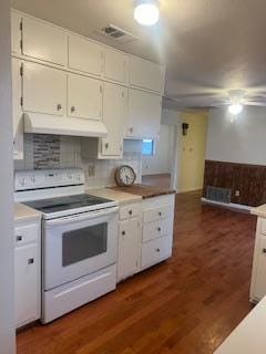 kitchen featuring dark hardwood / wood-style floors, white cabinetry, decorative backsplash, and electric stove