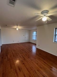 unfurnished living room with dark hardwood / wood-style floors and ceiling fan