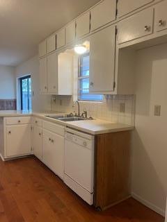 kitchen with decorative backsplash, dishwasher, and white cabinets