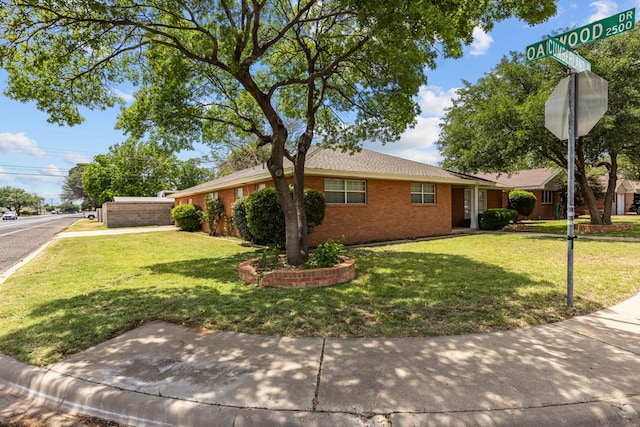 view of front facade featuring brick siding and a front lawn