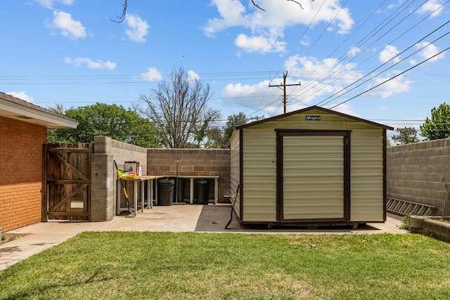 view of shed featuring a fenced backyard and a gate