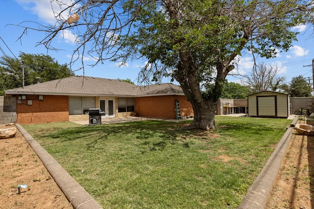 back of property with a storage shed, an outbuilding, brick siding, and a lawn