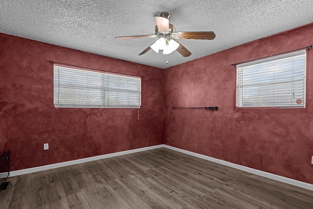 unfurnished room featuring ceiling fan, a wealth of natural light, and wood finished floors