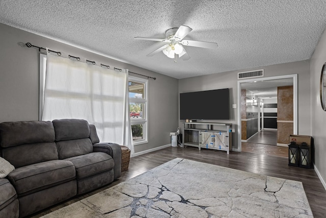 living area featuring a textured ceiling, visible vents, wood finished floors, and ceiling fan