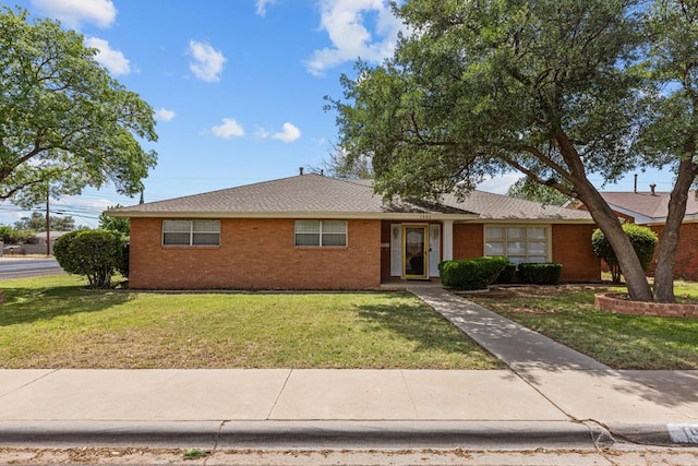 ranch-style home featuring brick siding and a front lawn