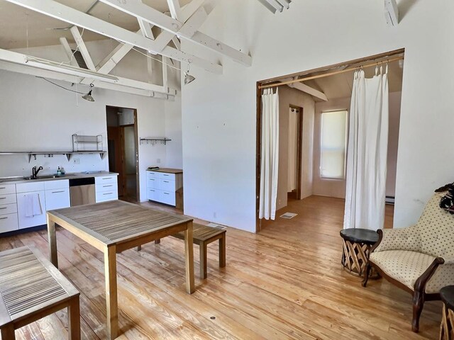 308 E Murphy St, Marfa, TX 79843 - dining area featuring light wood-style flooring, a baseboard radiator, and high vaulted ceiling