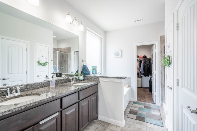 1614 Laguna Meadows Trl, Midland, TX 79705 - full bath featuring a shower stall, double vanity, a bath, a spacious closet, and tile patterned floors