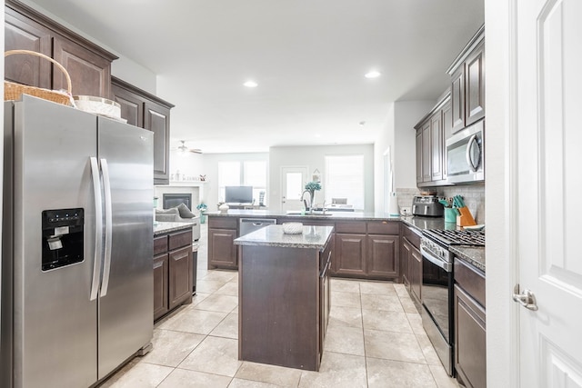 1614 Laguna Meadows Trl, Midland, TX 79705 - kitchen with appliances with stainless steel finishes, a peninsula, dark brown cabinets, a ceiling fan, and recessed lighting