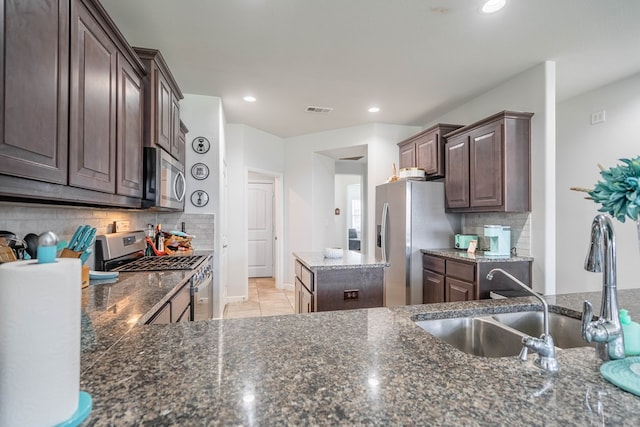 1614 Laguna Meadows Trl, Midland, TX 79705 - kitchen with appliances with stainless steel finishes, dark brown cabinetry, decorative backsplash, dark stone counters, and recessed lighting