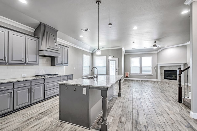 kitchen featuring ornamental molding, ceiling fan, a sink, visible vents, and gray cabinets