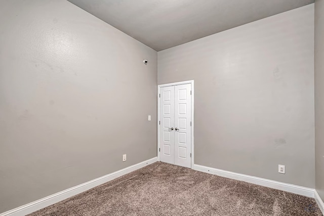 spare room featuring baseboards and carpet flooring