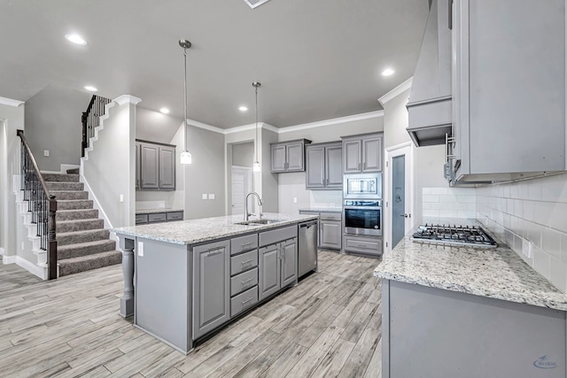 kitchen featuring light wood-style flooring, a sink, stainless steel appliances, gray cabinetry, and ornamental molding