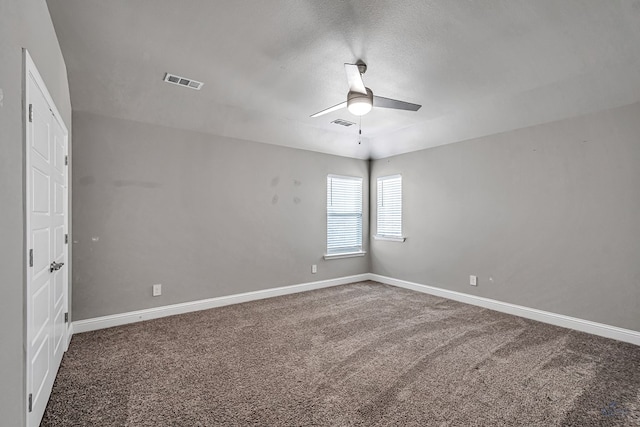 carpeted spare room featuring a ceiling fan, baseboards, and visible vents