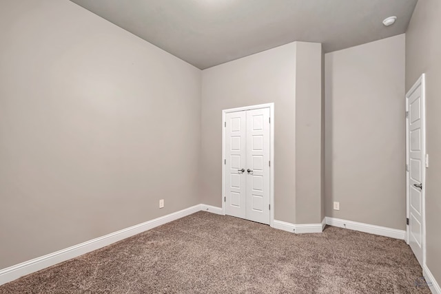 empty room featuring baseboards and carpet floors