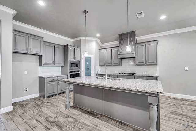 kitchen with custom exhaust hood, visible vents, a sink, stainless steel appliances, and gray cabinets