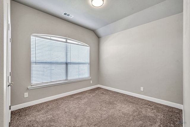 carpeted spare room featuring baseboards, visible vents, and vaulted ceiling