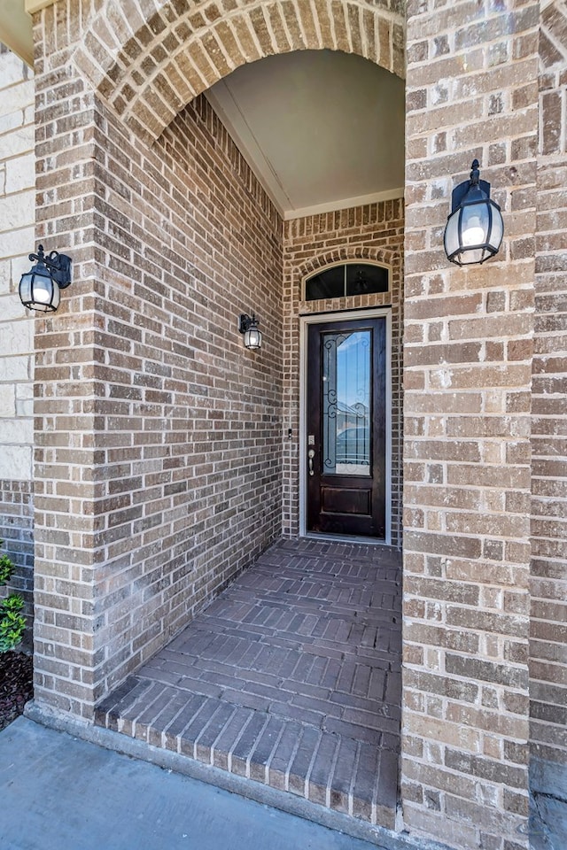 entrance to property featuring brick siding