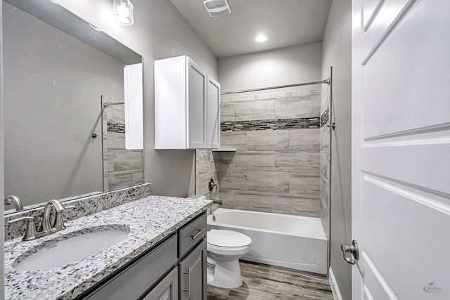 bathroom with toilet, wood finished floors, bathtub / shower combination, visible vents, and vanity