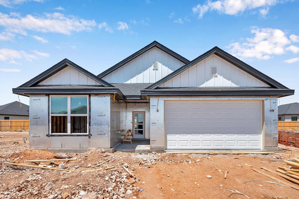 view of front of house featuring fence, board and batten siding, and an attached garage