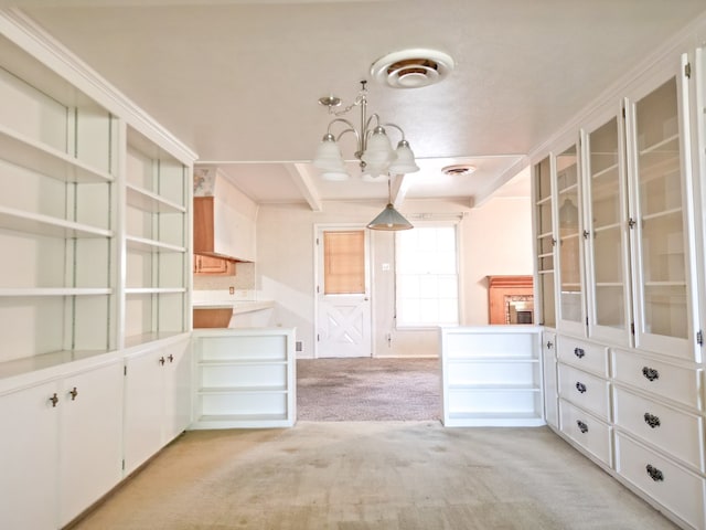 2809 E 17th St, Odessa, TX 79761 - kitchen with a chandelier, light carpet, glass insert cabinets, and white cabinetry