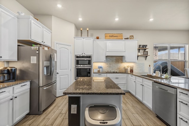 1214 Yancy St, Odessa, TX 79765 - kitchen featuring appliances with stainless steel finishes, white cabinets, wood tiled floors, tasteful backsplash, and recessed lighting