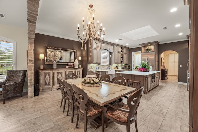 4309 Greenville Dr, Midland, TX 79705 - dining area featuring arched walkways, a skylight, crown molding, a chandelier, and recessed lighting