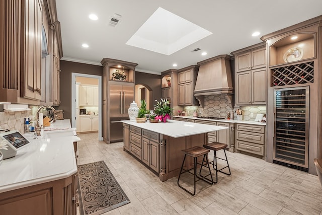 4309 Greenville Dr, Midland, TX 79705 - kitchen with beverage cooler, appliances with stainless steel finishes, crown molding, premium range hood, and a kitchen island