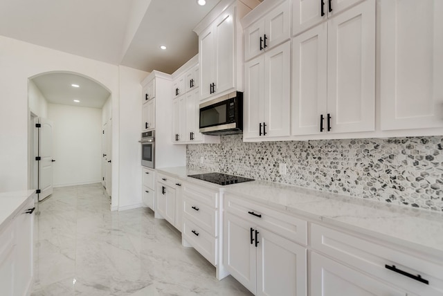 12045 W Palomino Ave, Odessa, TX 79764 - kitchen with stainless steel appliances, arched walkways, white cabinets, tasteful backsplash, and recessed lighting