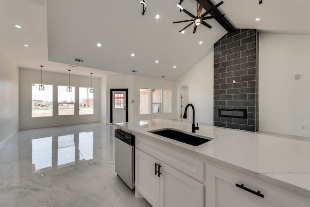 12045 W Palomino Ave, Odessa, TX 79764 - kitchen featuring dishwasher, light marble finish floors, white cabinetry, open floor plan, and a tile fireplace