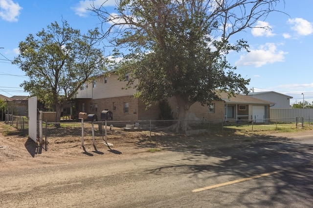 5714 Ector Ave, Odessa, TX 79714 - view of front of home with brick siding, a fenced front yard, a garage, and dirt driveway