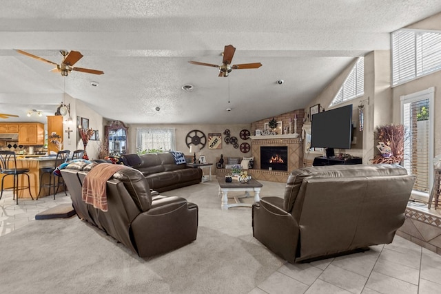 5714 Ector Ave, Odessa, TX 79714 - living area featuring ceiling fan, a textured ceiling, lofted ceiling, a fireplace, and light tile patterned flooring