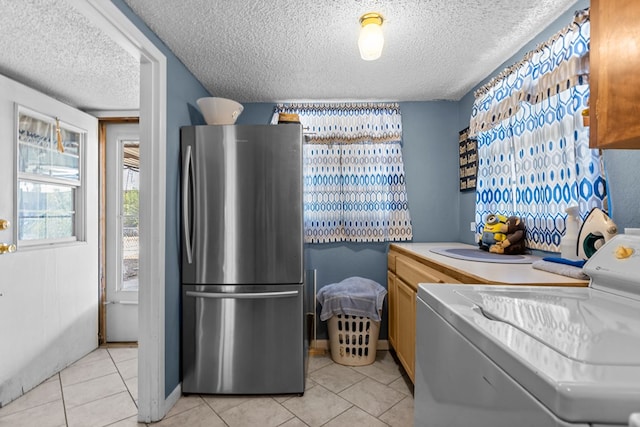 5714 Ector Ave, Odessa, TX 79714 - kitchen featuring freestanding refrigerator, washer / dryer, a textured ceiling, light tile patterned floors, and light countertops