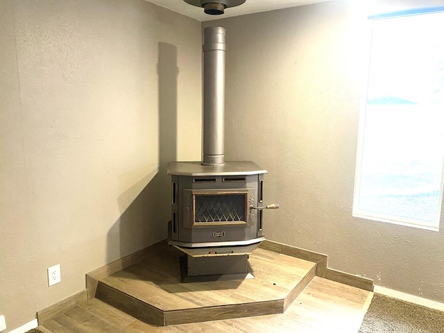 906 S Franklin Ave, Monahans, TX 79756 - detailed view of a wood stove, wood finished floors, baseboards, and a textured wall