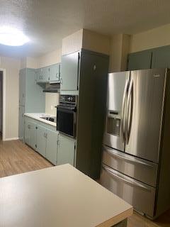 906 S Franklin Ave, Monahans, TX 79756 - kitchen featuring black appliances, light countertops, and light wood finished floors