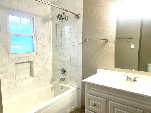 906 S Franklin Ave, Monahans, TX 79756 - bathroom with vanity, toilet, shower / bathtub combination, and a textured wall