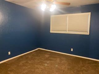 906 S Franklin Ave, Monahans, TX 79756 - carpeted spare room with ceiling fan and baseboards