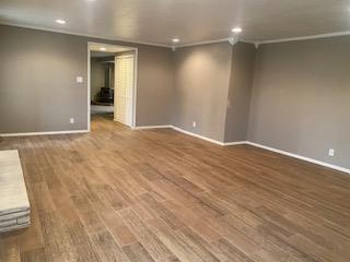 906 S Franklin Ave, Monahans, TX 79756 - spare room with recessed lighting, baseboards, wood finished floors, and crown molding