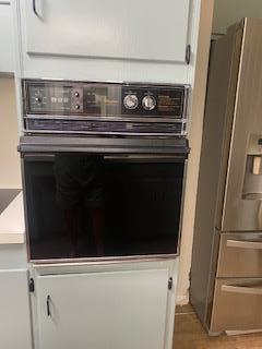 906 S Franklin Ave, Monahans, TX 79756 - kitchen view of oven, stainless steel fridge with ice dispenser, and white cabinetry