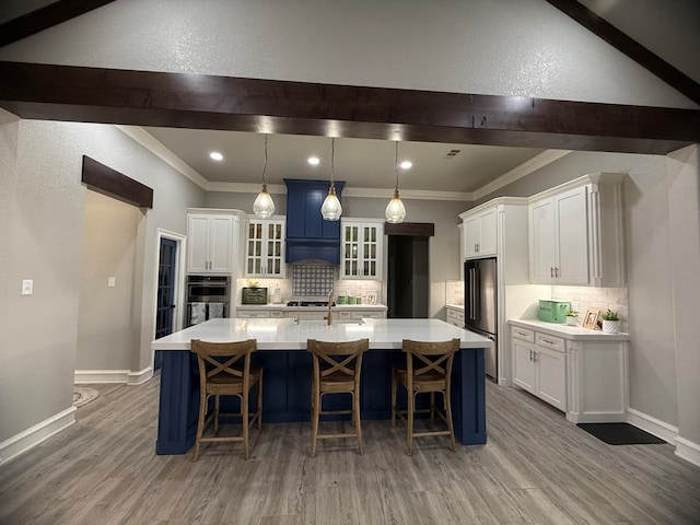 kitchen with light countertops, white cabinets, appliances with stainless steel finishes, and decorative backsplash