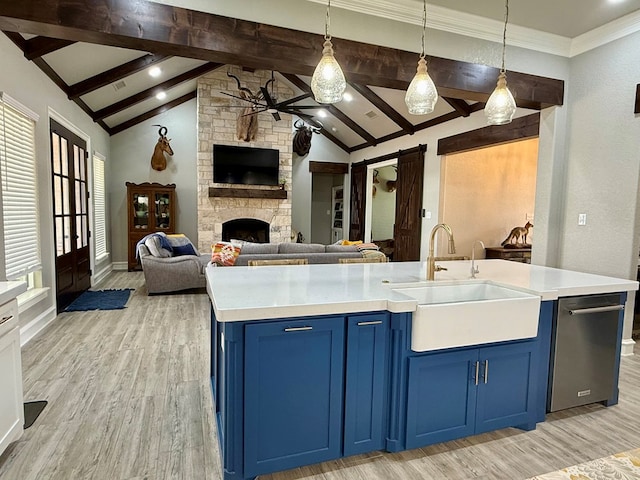 kitchen with a sink, open floor plan, vaulted ceiling with beams, light wood-type flooring, and blue cabinetry