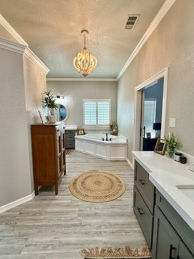 bathroom with a textured wall, visible vents, a textured ceiling, and wood finished floors